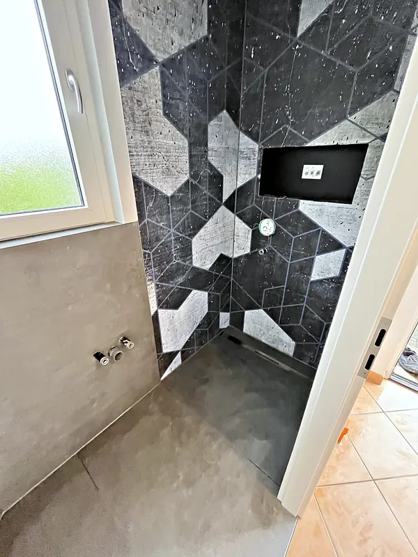Dusche mit geometrischer Motivtapete neben Fenster